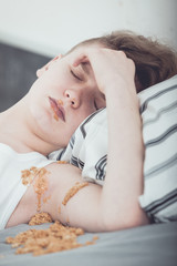 Fototapeta na wymiar Teenage Boy Lying in Bed Covered in Vomit