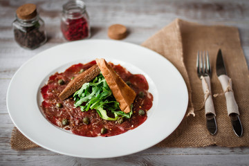 Meat carpaccio of beef on wood table