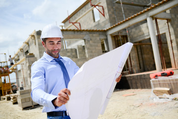 portrait of handsome young man architect on a building industry construction site