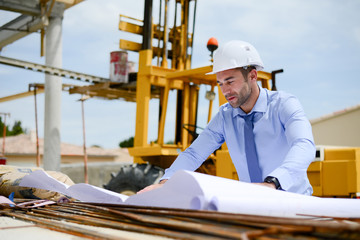portrait of handsome young man architect on a building industry construction site
