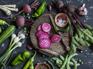 Chopped beets, peppers, onions, green beans, spices on a dark background. Fresh garden vegetables....