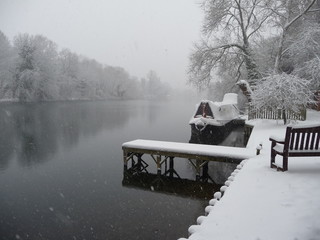 Winter shot of the River Thames near Maidenhead, with snow covering the riverbank, a small jetty...