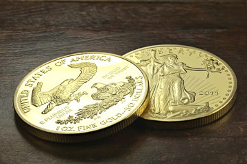 1 ounce American gold eagle bullion coins on wooden background
