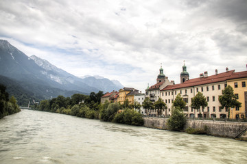 Typical Austrian houses at the embankment of the Inn river in Innsbruck, Austria with the Alps in the background
