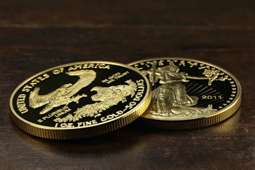 1 ounce American gold eagle bullion coins on wooden background 