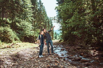 Obraz premium A couple of tourists Hiking backpacks are viewing beautiful landscape mountain river