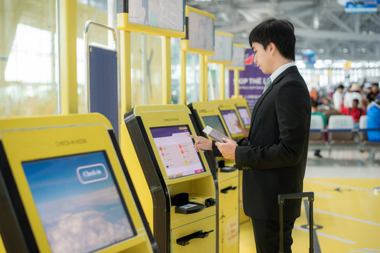 Business travel - Asian business man using self check-in kiosks