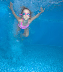 Small girl jumps and having fun in water. 