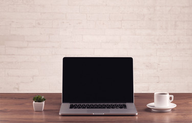 Office desk closeup with white brick wall