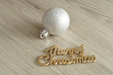 A silver christmas tree bauble and merry christmas