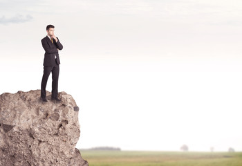 Happy salesman on cliff in the country