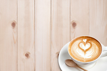 A cup of coffee latte with spoon on wood blackground