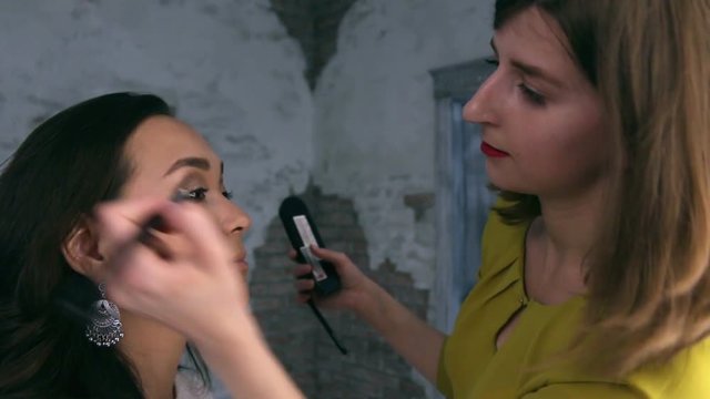 Visagist puts shadows on the eyelid, close up