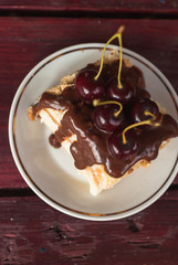 piece of cake with chocolate icing and cherries, puff pastry Napoleon  on a white plate,