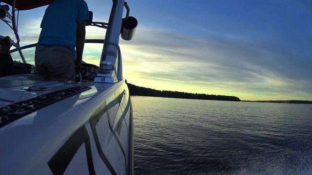 Boat Driver Standing Back View, Young people hanging out on a wakeboard sport boat in the summer