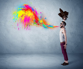Hipster guy shouting colorful paint on wall