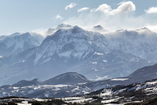 Winter morning view of the Grand Morgon peak with wind blowing fresh snow. Hautes Alpes, Southern French Alps, France