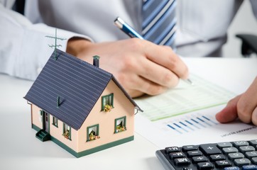 Businessman calculate the cost of building and maintaining home