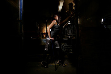 Fototapeta na wymiar Brunette model in an abandoned workshop is posing