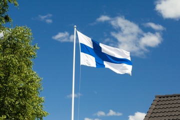 Naklejka premium Flag of Finland on blue sky background.