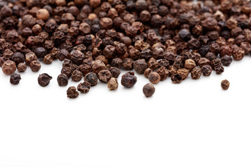 Black pepper seeds on white background