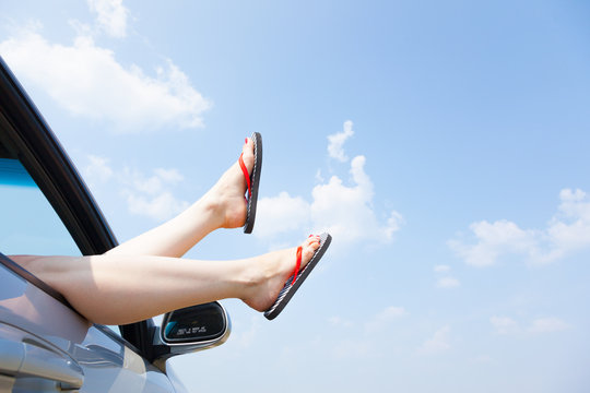 Female Legs Dangling From The Open Car Window