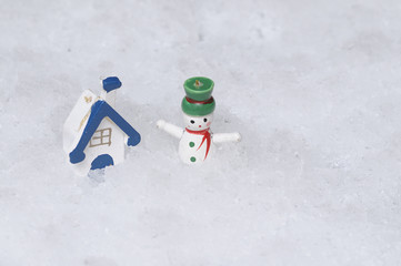 A house and snowman displayed in artificial snow