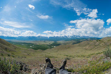 feet in the shoes against the backdrop of the mountains