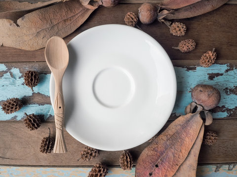 Empty plate with wooden spoon on wooden background. Top view 