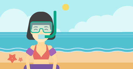 Woman with snorkeling equipment on the beach.