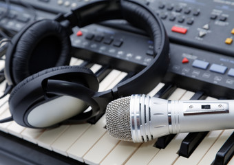 Fototapeta na wymiar microphone and ear-phones lie on the keyboard
