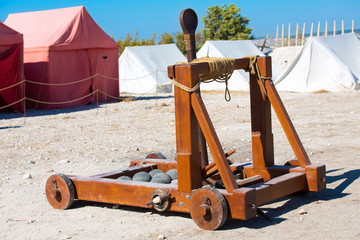 ancient Roman catapult with cannonballs in a military camp