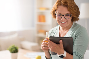 Positive senior woman using tablet