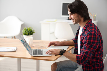 Positive man using laptop