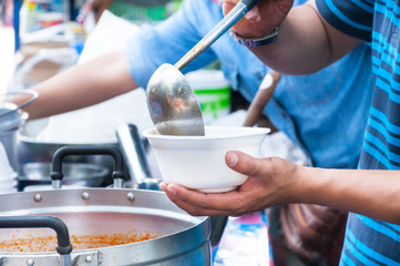 hand  holding Spoon food in the foam tray ,streetfood