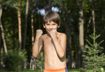 portrait of a boy in nature which shows his muscles