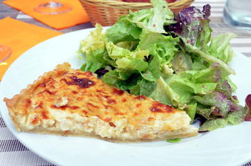 slice of french quiche with salad served on a plate