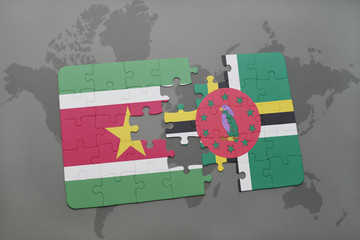 puzzle with the national flag of suriname and dominica on a world map background.