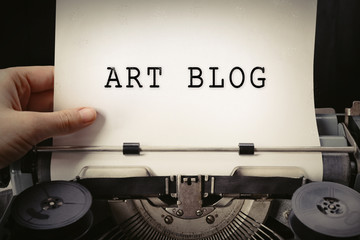 Hand working on old typewriter with paper, close up. Blog concept