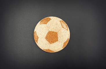 Football ball symbol on cork, on grey background, top view