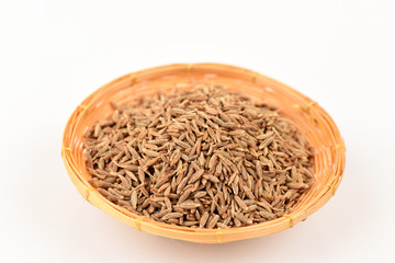 Cumin seeds, spices, medicinal properties in a basket on a white background.