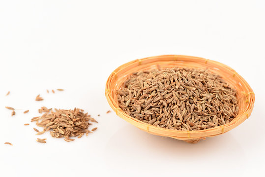 Cumin seeds, spices, medicinal properties in a basket on a white background.