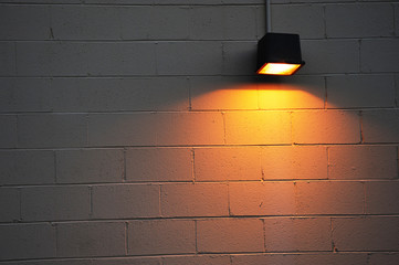 street lamp on the wall illuminating the night in yello w light