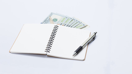 Naklejka premium Notebook and US dollar banknote, for business concept