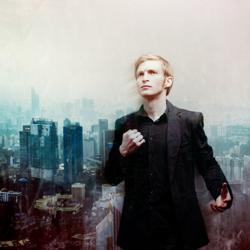 ambitious young man on background of megalopolis, double exposure