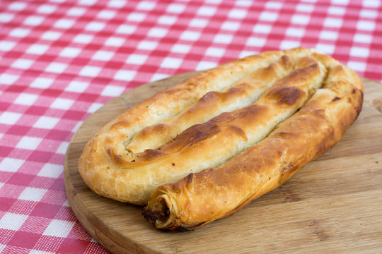 Round domestic burek pie with meat on the wooden board