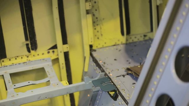 Drilling holes in body of plane between baffles with a drill bit.