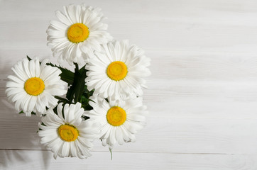 bouquet of daisies on white wooden table