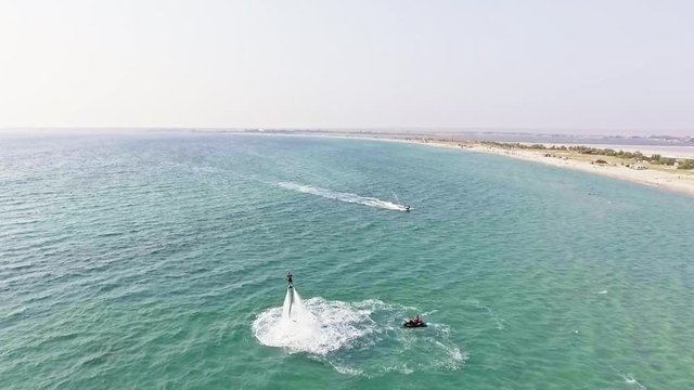 Man flying over sea on flyboard. Aerial view from copter. Full HD video