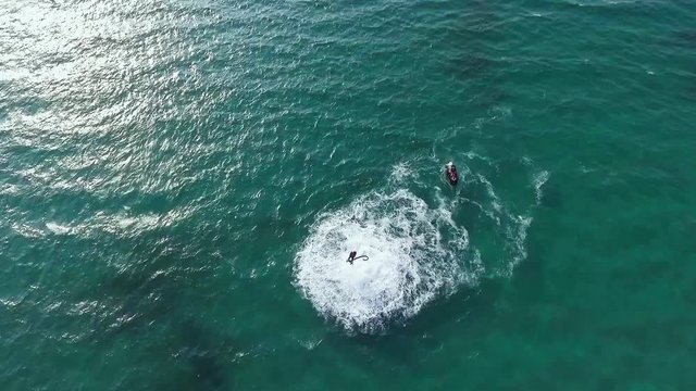 Man flying over sea on flyboard. Aerial view from copter. Full HD video